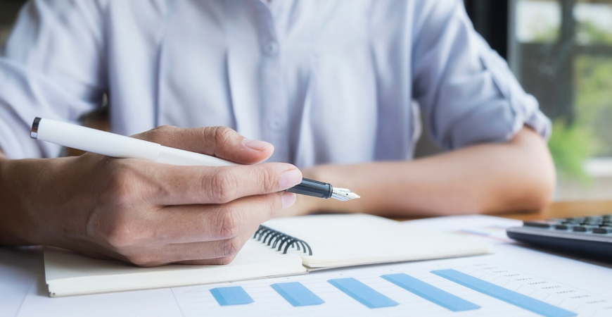 Erros Fiscais Comuns: pessoa analisando planilhas e anotações, representando conferência fiscal e prevenção de erros tributários.