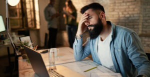 Crescimento das Pequenas Empresas: empresário preocupado no escritório, simbolizando desorganização fiscal, multas e impacto no crescimento.